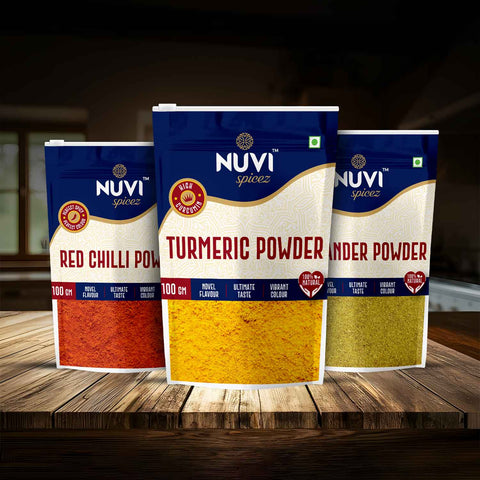Daily Kitchen Essentials featuring NUVI spice packets of turmeric, red chilli, and coriander powders on a wooden table.