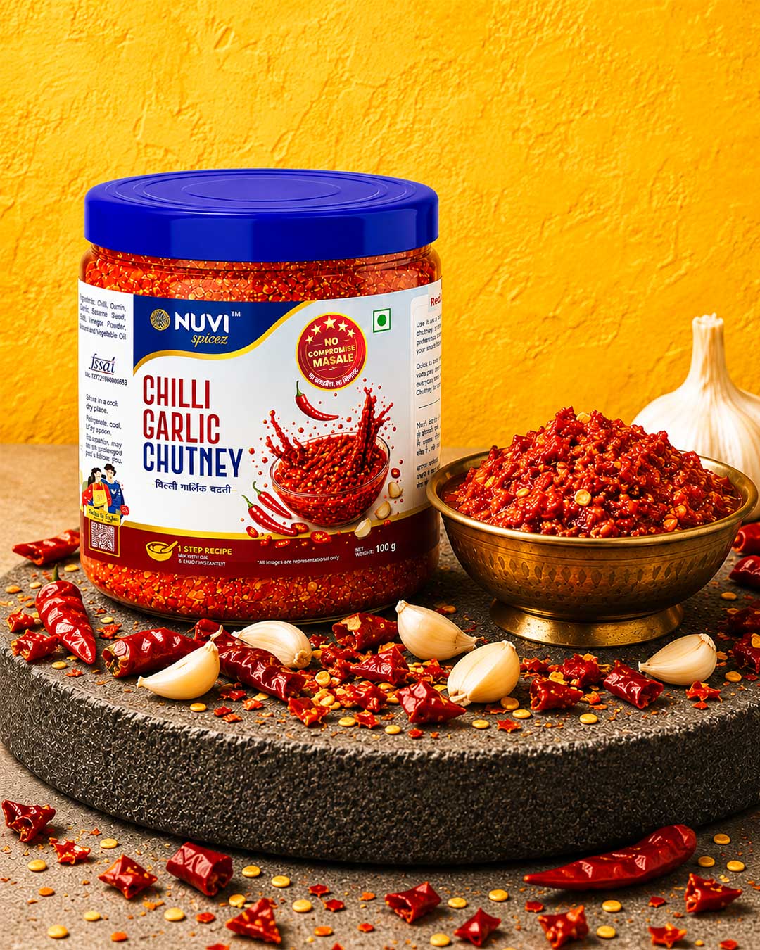 NUVI Chilli Garlic Chutney Powder jar with chutney and garlic on a rustic table setup.